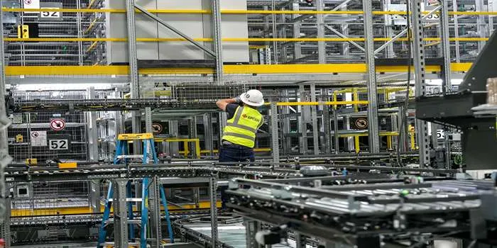 فردی که با لباس کار در حال تعمیر تاسیسات مکانیکی ساختمان است.