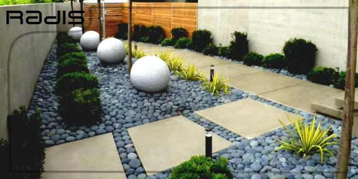 اصول طراحی فضای سبز + 4 نکته مهم _ محوطه ویلایی که با سنگ های ریز و درشت و گیاهان سبز تزیین شده است.